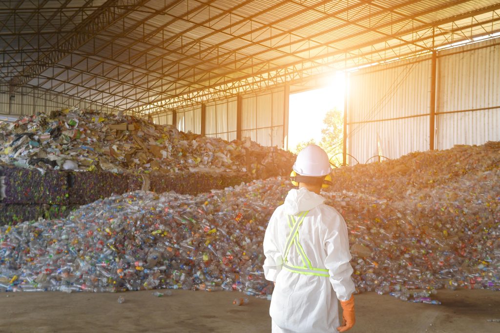 Mann vor einem Berg aus Plastikmüll